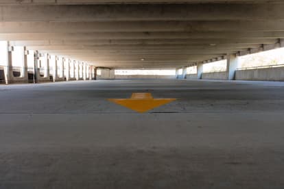 an inspector checking the floor of a parking garage.