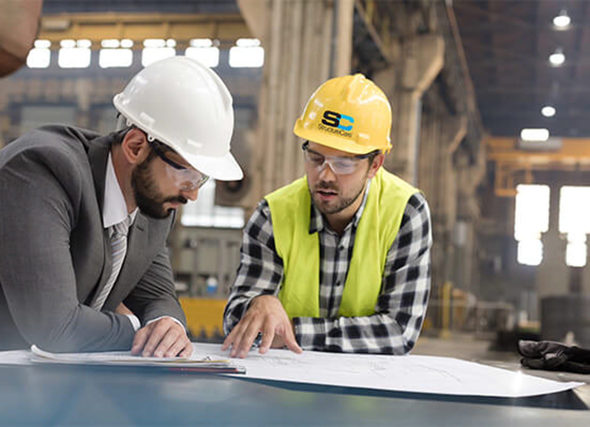 Two men reviewing structural repair plans