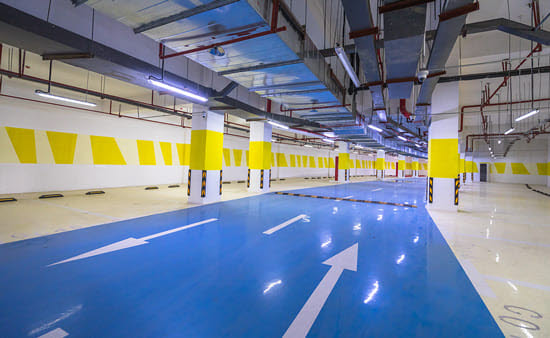 Clean parking garage with blue parking deck and yellow pillars